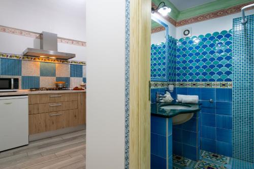 ポジターノにあるAmore Rentals - Casa Barbera Bの青いタイル張りのバスルーム(シンク付)、キッチン