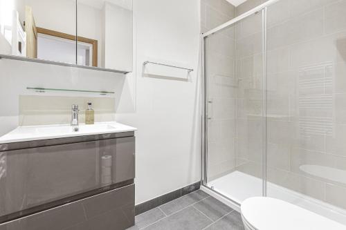uma casa de banho com um chuveiro, um WC e um lavatório. em Spacious 1 BR apt w 2 king bed by Tent serviced apartments em Farnborough