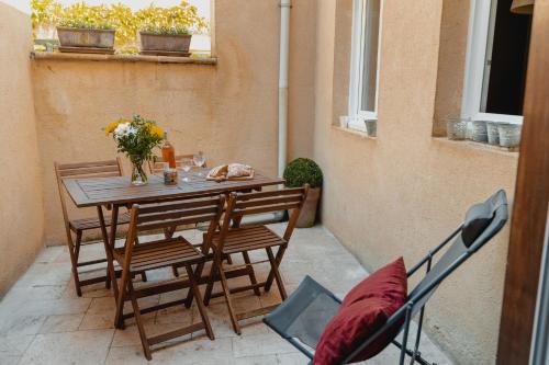 une table et des chaises sur une terrasse avec une table dans l'établissement Location Secrète Sarlat, à Sarlat-la-Canéda