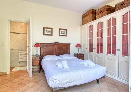 a bedroom with a large bed with white sheets at Beautiful Air-Con House 5min from the Beaches in Cannes