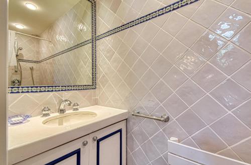 ein Bad mit einem Waschbecken und einem Spiegel in der Unterkunft Beautiful Air-Con House 5min from the Beaches in Cannes