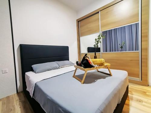 una mujer sentada en una silla en una habitación con dos camas en Mupify Homestay Gala City Gala Residences A4 en Kuching