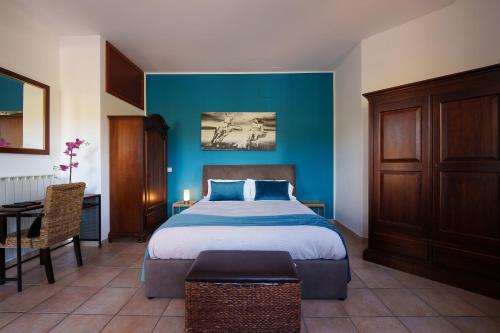 1 dormitorio con cama y pared azul en La Dolce Vita, en Regalbuto
