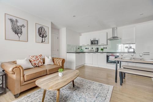 a living room with a couch and a table at Modern 1 BR apt near town centre, perfect for long stays in Egham