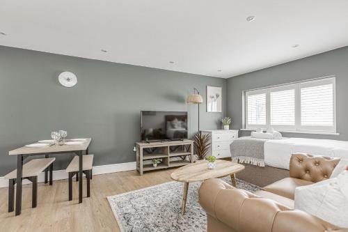 a living room with a bed and a table at Modern 1 BR apt near town centre, perfect for long stays in Egham