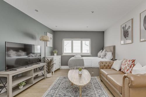 a living room with a couch and a bed and a television at Modern 1 BR apt near town centre, perfect for long stays in Egham