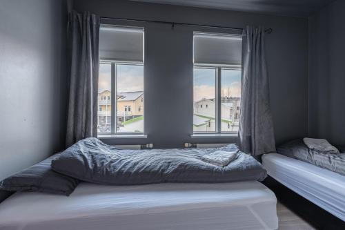 Schlafzimmer mit einem Bett und einem Fenster mit Aussicht in der Unterkunft Day Dream Strandgata 11 in Akureyri
