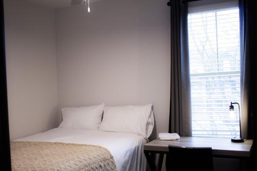 a bedroom with a bed and a desk and a window at Stunning 4-BR Houses with On-Site Pool in Bloomington