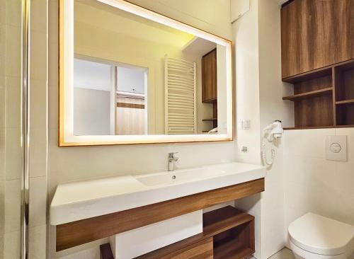bagno con lavandino e specchio di HOLIDAY HOME Bel Mare 109b z tarasem i ogródkiem a Międzyzdroje