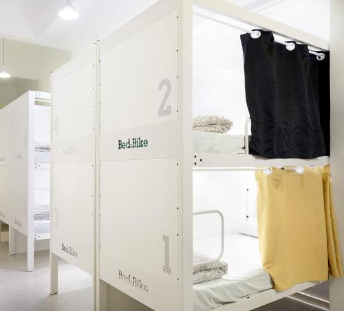 バルセロナにあるベッド アンド バイク バルセロナの二段ベッド2台とクローゼットが備わる客室です。