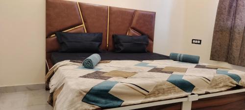 uma cama grande com uma cabeceira castanha num quarto em Pleasant Stay B&B em Amritsar
