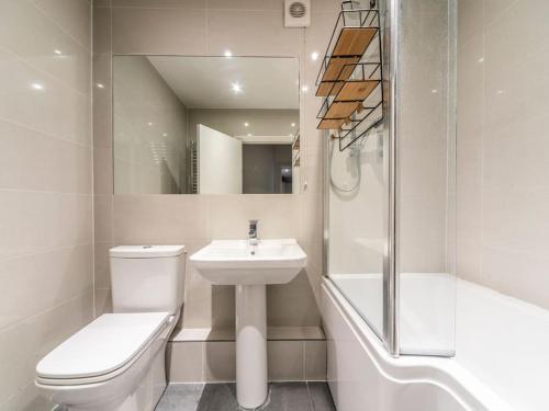 La salle de bains est pourvue de toilettes, d'un lavabo et d'une douche. dans l'établissement Surbiton Garden Flat, à Surbiton