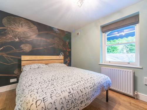 a bedroom with a bed and a painting on the wall at Comfy Apartment With Garden in Surbiton in Surbiton