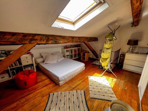 ein Schlafzimmer mit einem Bett im Dachgeschoss mit einem Fenster in der Unterkunft Tessya - Central, Mer à 150m, Spacieux - by TGB in Ajaccio