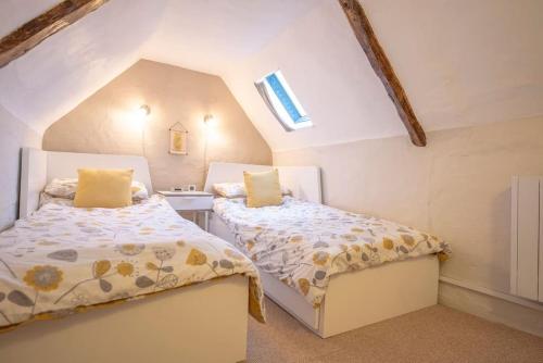 two beds in a room with a attic at Vela Art Gallery - Holiday Apartment in Saxmundham