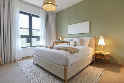 a bedroom with a bed and a large window at HiGuests - Coastal Chic Luxurious Retreat at Port de la Mer in Dubai