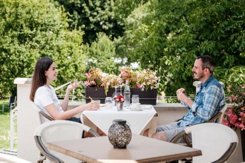 a man and a woman sitting at a table at Hotel-Restaurant Dimmer - Mullerthal in Wallendorf pont