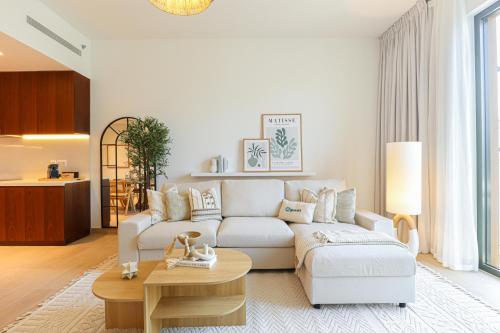 a living room with a white couch and a table at HiGuests - Coastal Chic Luxurious Retreat at Port de la Mer in Dubai