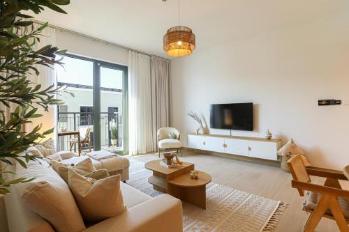 a living room with a couch and a tv at HiGuests - Coastal Chic Luxurious Retreat at Port de la Mer in Dubai