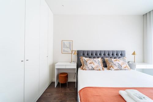 a white bedroom with a bed and a desk at T1 Urban Charm Central City Escape in Braga