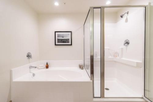 uma casa de banho branca com um chuveiro e uma banheira em Downtown Santa Monica - 2BDR & 2 BTH for 6 Guests! em Los Angeles