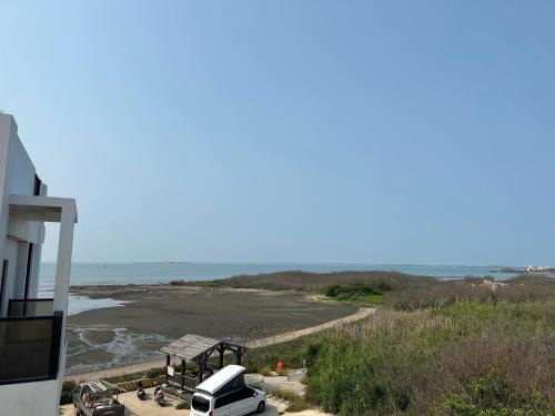 a view of a beach with a car parked next to a building at Diving Duck B&B in Magong