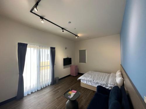 a room with a bed and a tv in it at Diving Duck B&B in Magong