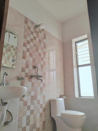 a bathroom with a toilet and a sink at HOTEL OCEAN in Lumbini