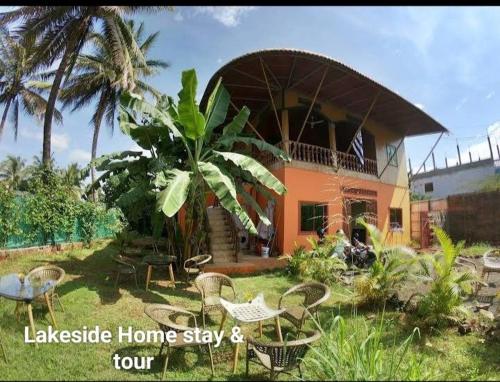 Uma casa com um monte de cadeiras à frente. em Ratanakiri Lakeside Homestay & Tours em Banlung
