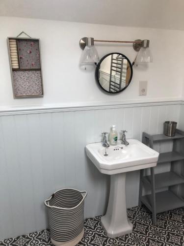 een badkamer met een wastafel en een spiegel bij Gorgeous North Pembs Cottage in Saint Dogmaels