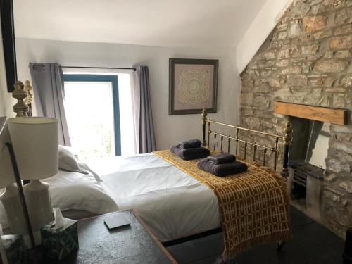 een slaapkamer met een bed en een stenen muur bij Gorgeous North Pembs Cottage in Saint Dogmaels