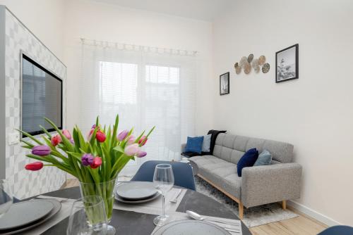 ein Wohnzimmer mit einem Tisch und einem Sofa in der Unterkunft Unique Apartment with Balcony in Swinoujscie by Rent like home in Świnoujście
