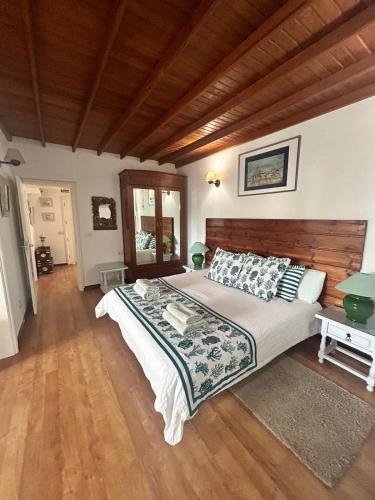 a bedroom with a large bed and wooden floors at VILLA VEGUETA in La Vegueta