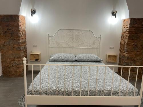un letto con testiera bianca in una stanza di Catania Centro Storico a Catania