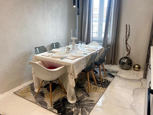 mesa de comedor con mantel y sillas blancas en Francesca's Minimal-Chic Design apartment, en Montecatini Terme