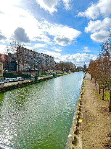 a river with cars parked on the side of it at Peace & Love Hostel in Paris