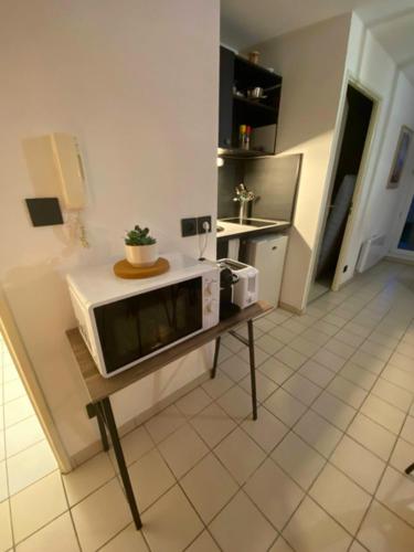 cocina con microondas sobre una mesa en Terracotta - Cosi - WIFI - Parking - Terrasse, en Saint-Orens-de-Gameville