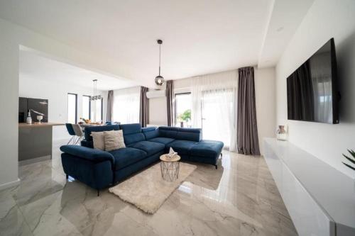 un soggiorno con divano blu e tavolo di Apartmani Carmen a Bibinje (Bibigne)
