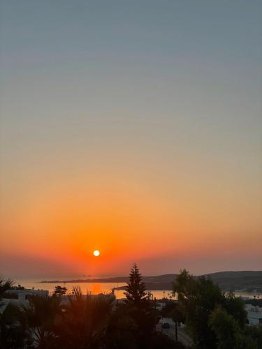 una puesta de sol sobre el océano con el sol en el cielo en thEros - apartment 1, en Parikia