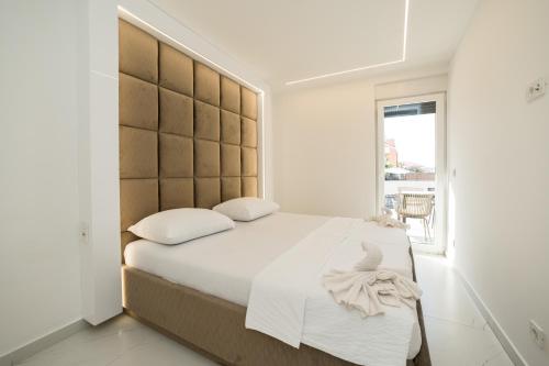 ein Schlafzimmer mit einem großen Bett mit einem großen Kopfteil in der Unterkunft Apartments Ante in Novalja