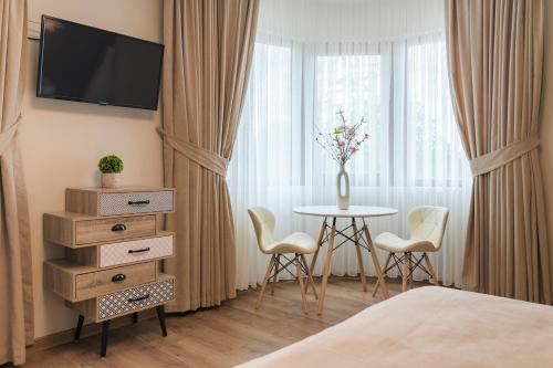 Habitación de hotel con mesa con sillas y TV en Къщата, en Isperikh