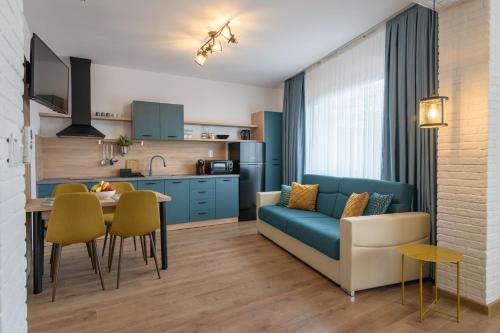 ein Wohnzimmer und eine Küche mit einem Sofa und einem Tisch in der Unterkunft Къщата in Isperikh