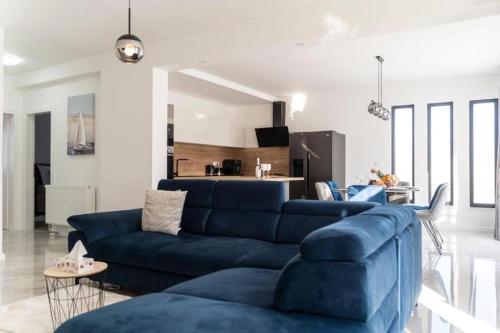 sala de estar con sofá azul y cocina en Apartmani Carmen en Bibinje