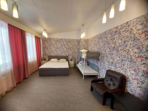 ein Schlafzimmer mit einem Bett und einem Stuhl in einem Zimmer in der Unterkunft Hotel Ilomantsi North Star in Ilomantsi
