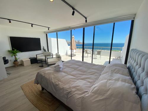 - une chambre avec un lit et une vue sur la plage dans l'établissement Moderno Depto Estudio frente a Playa Amarilla, à Concón