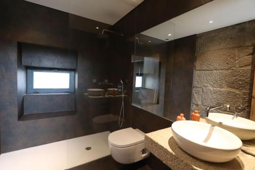 ein Badezimmer mit zwei Waschbecken und einem WC in der Unterkunft Quinta de Travanca - Casa do Páteo, Baião, Douro in Baião