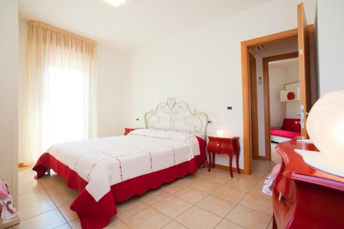 カオルレにあるResidence Roberta con piscina - Agenzia Cocalのベッドルーム1室(ベッド1台、赤と白の毛布付)
