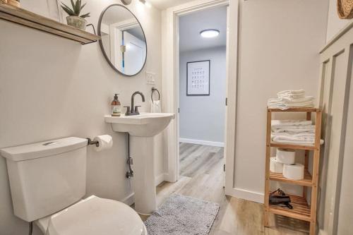 a bathroom with a toilet and a sink and a mirror at Extended Stays & Historic DT Basement Suite in Colorado Springs
