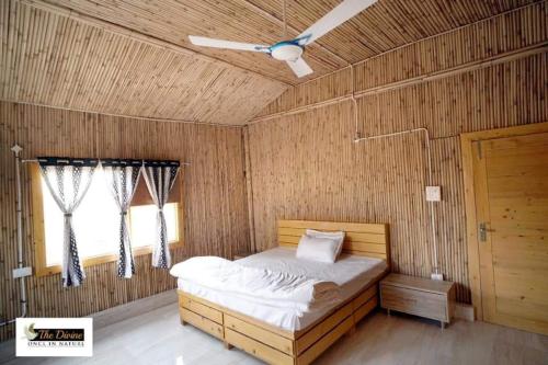 een slaapkamer met een bed en een plafondventilator bij The Divine - Once in Nature in Kalka