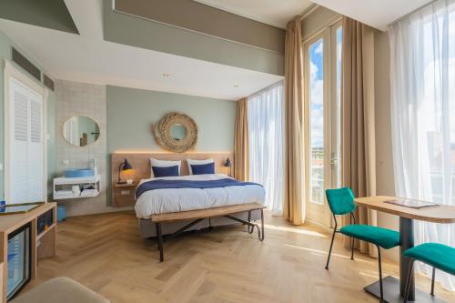 a bedroom with a bed and a large window at City Hotel Rembrandt in Leiden